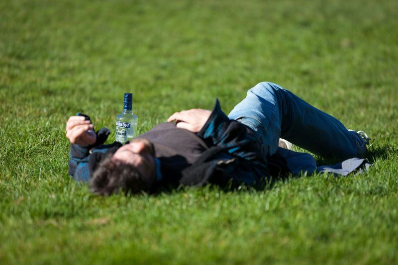 Hombre ebrio en el pasto